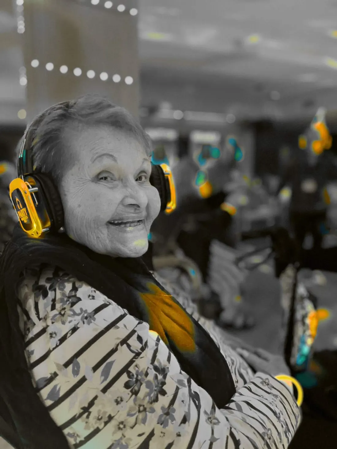 A resident smiling while wearing Sunny Sound headphones during an activity.